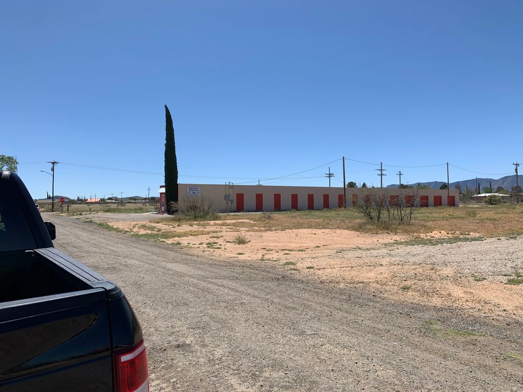 Open landscape with storage units and truck